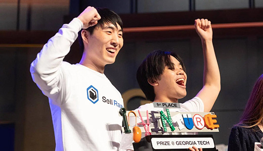 Two transfer students react to their 2023 InVenture Prize win as they are handed the trophy. The Georgia Tech transfer students won the competition for their startup company idea.